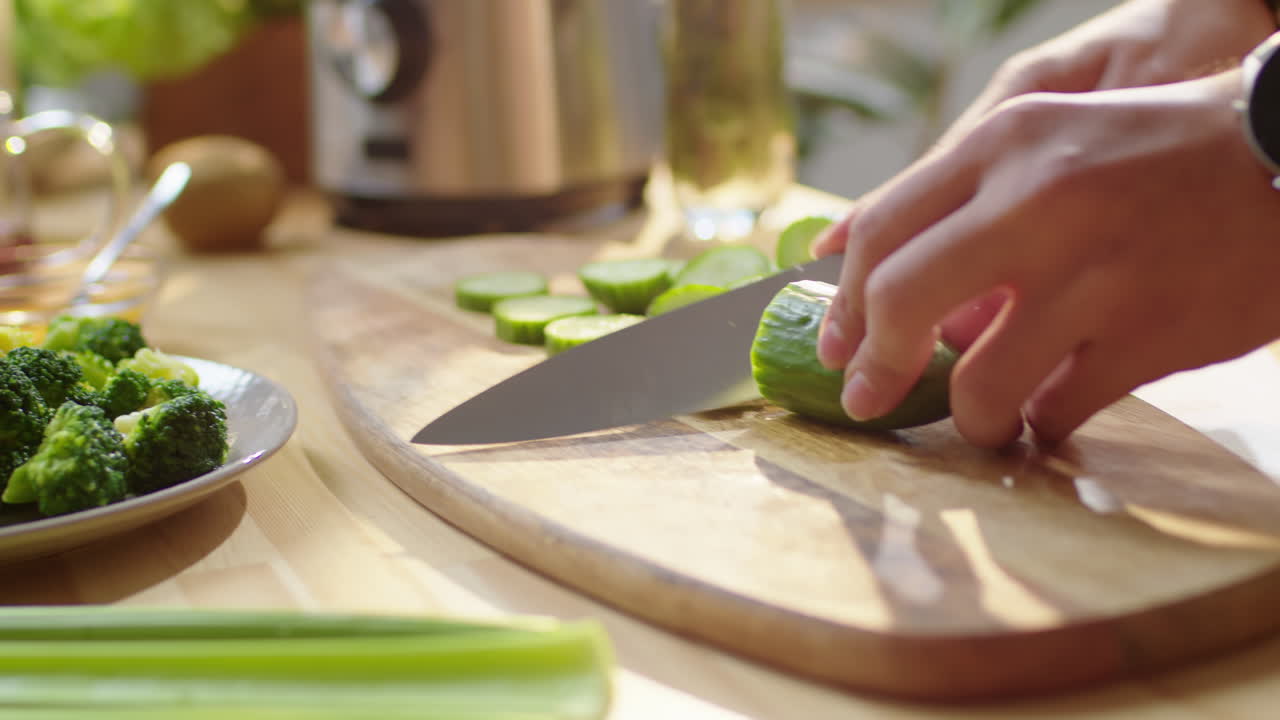 Hands of Man Cutting Fresh Cucumber