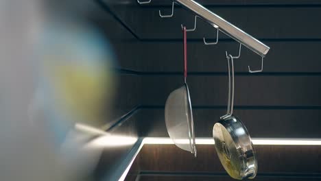 woman takes fine sieve hanging on kitchen organizer