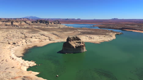 lone rock in wahweap bay with tranquil waters in utah, usa. - aerial shot