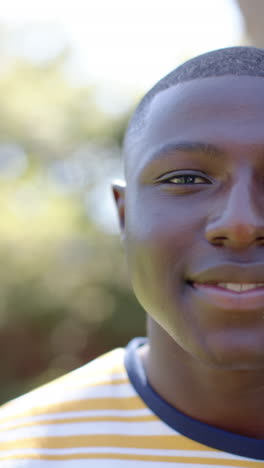 vertical video: smiling young man enjoying sunny day outdoors, feeling happy and relaxed