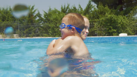 madre e hijo divirtiéndose en la piscina de casa