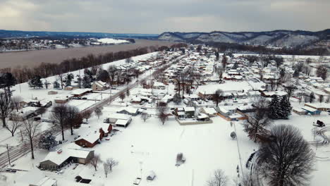 aerial view of city, mountains and river covered in snow