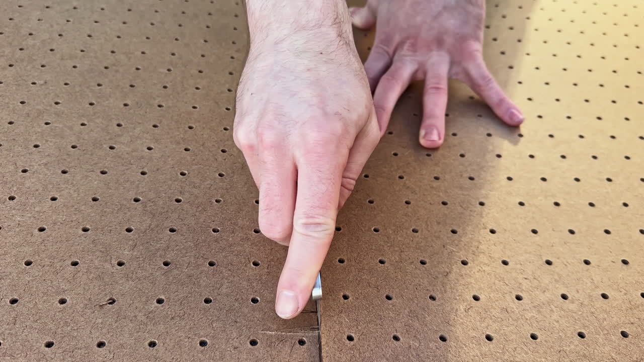 Mani lavorano con una tavola di legno su un tavolo in laboratorio di giorno mentre si preparano per compiti di assemblaggio e artigianato