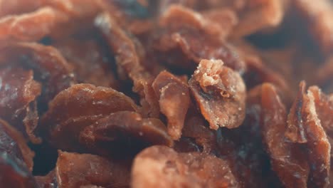 A-macro-close-up-shot-of-a-pile-of-dry-cranberry-in-a-bawl-on-a-rotating-stand,-slow-motion,-4k