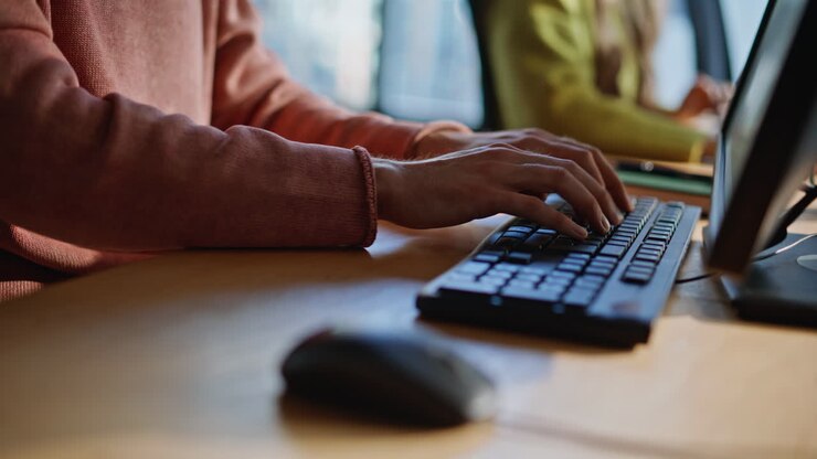 Hände, die eine Computermaus benutzen und auf einer Tastatur tippen, Nahaufnahme im Büro. Geschäftsmann arbeitet