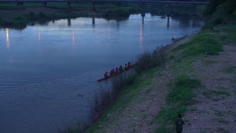 üben-Sie-Das-Drachenboot-Für-Den-Rennsport,-Der-Nach-Dem-Training-Bei-Sonnenuntergang-An-Land-Zieht,-Thailand