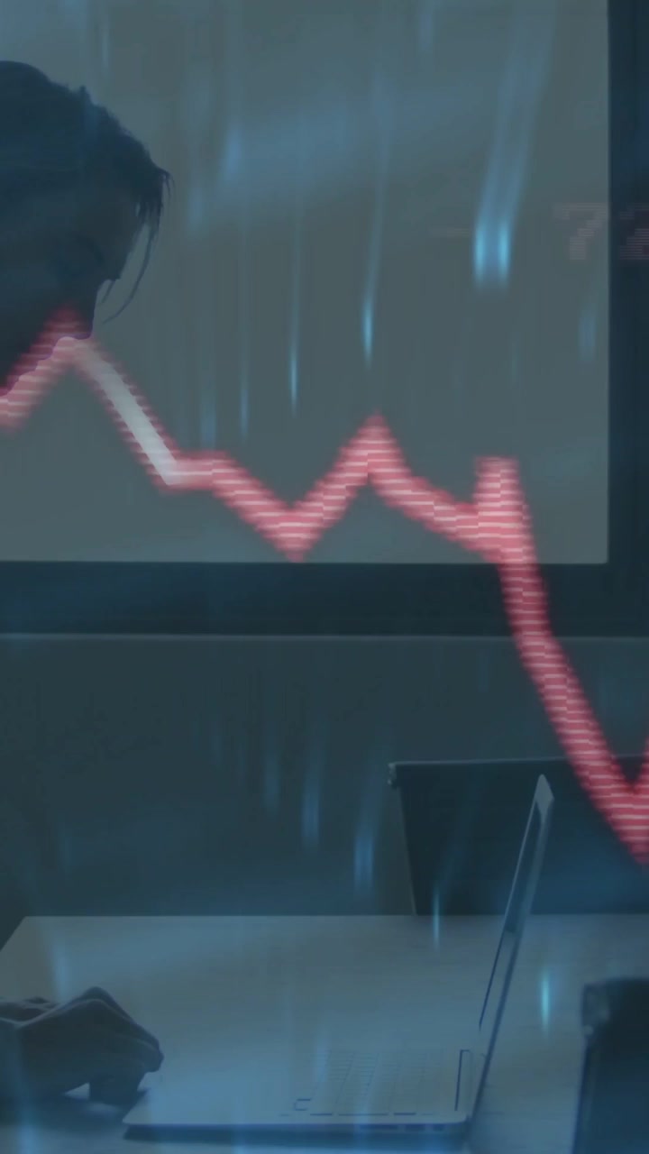 Vertical video: Woman typing on laptop after data update animating waveform across finance chart