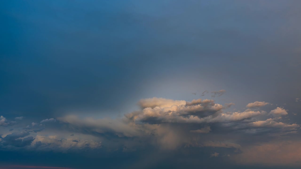 Colorful evening clouds flowing across a bright and dramatic sunset sky