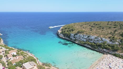 an aerial shot captures the breathtaking cala romántica in mallorca, revealing its turquoise waters, sandy beaches, and rugged cliffs from above.