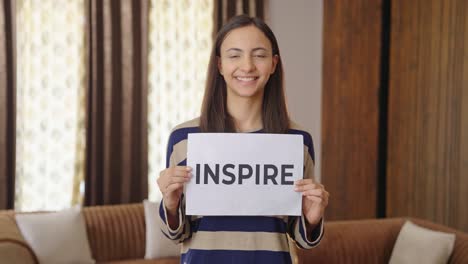 happy indian woman holding inspire banner