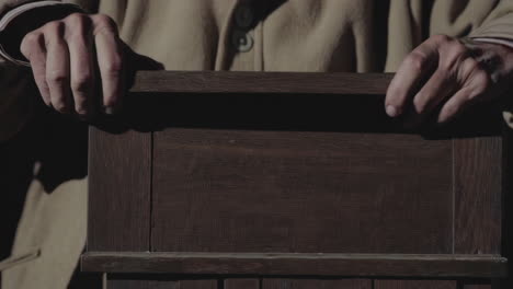 old man holding wooden box
