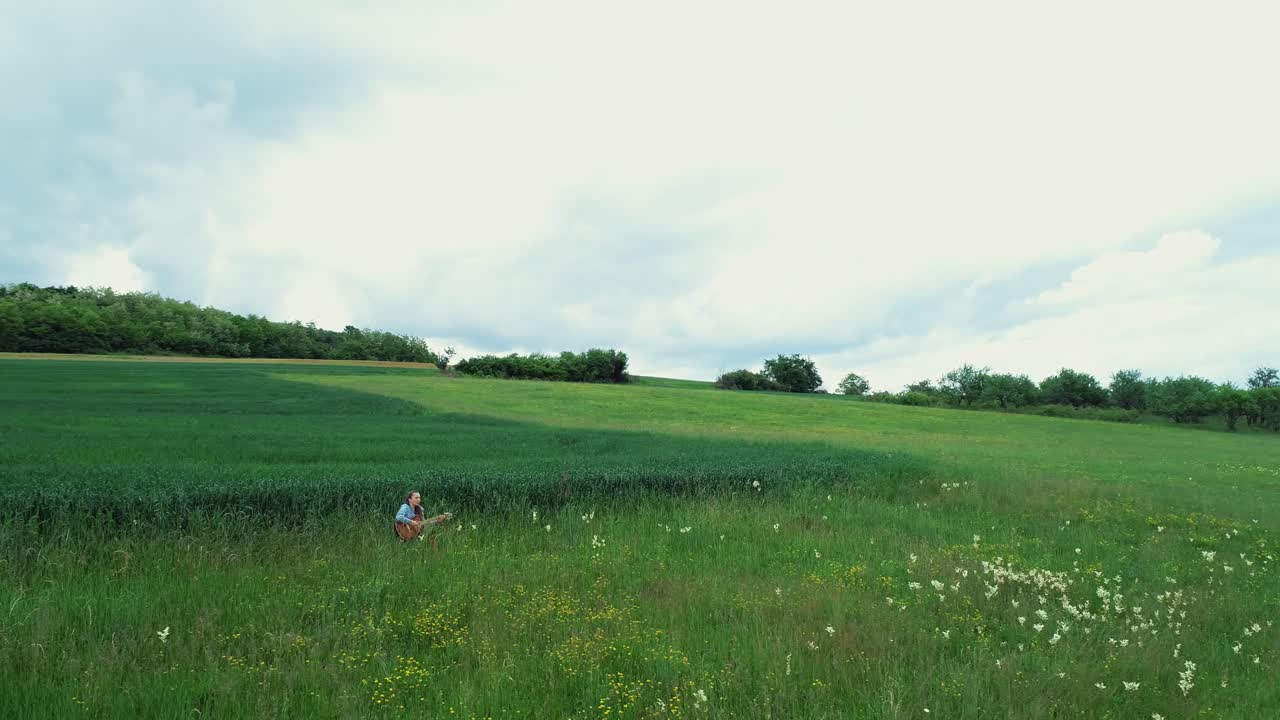 풀밭에 앉아 기타를 치는 여자
