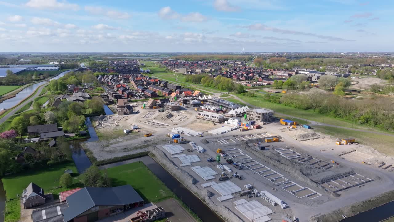 Luchtfoto van een bouwlocatie in vroege fase, omringd door velden, Nederland