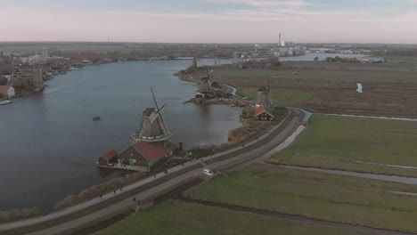 Aerial-view-on-windmills-in-a-typical-Dutch-landscape-with-rotating-wicks-on-a-bright-day-with-blue-sky