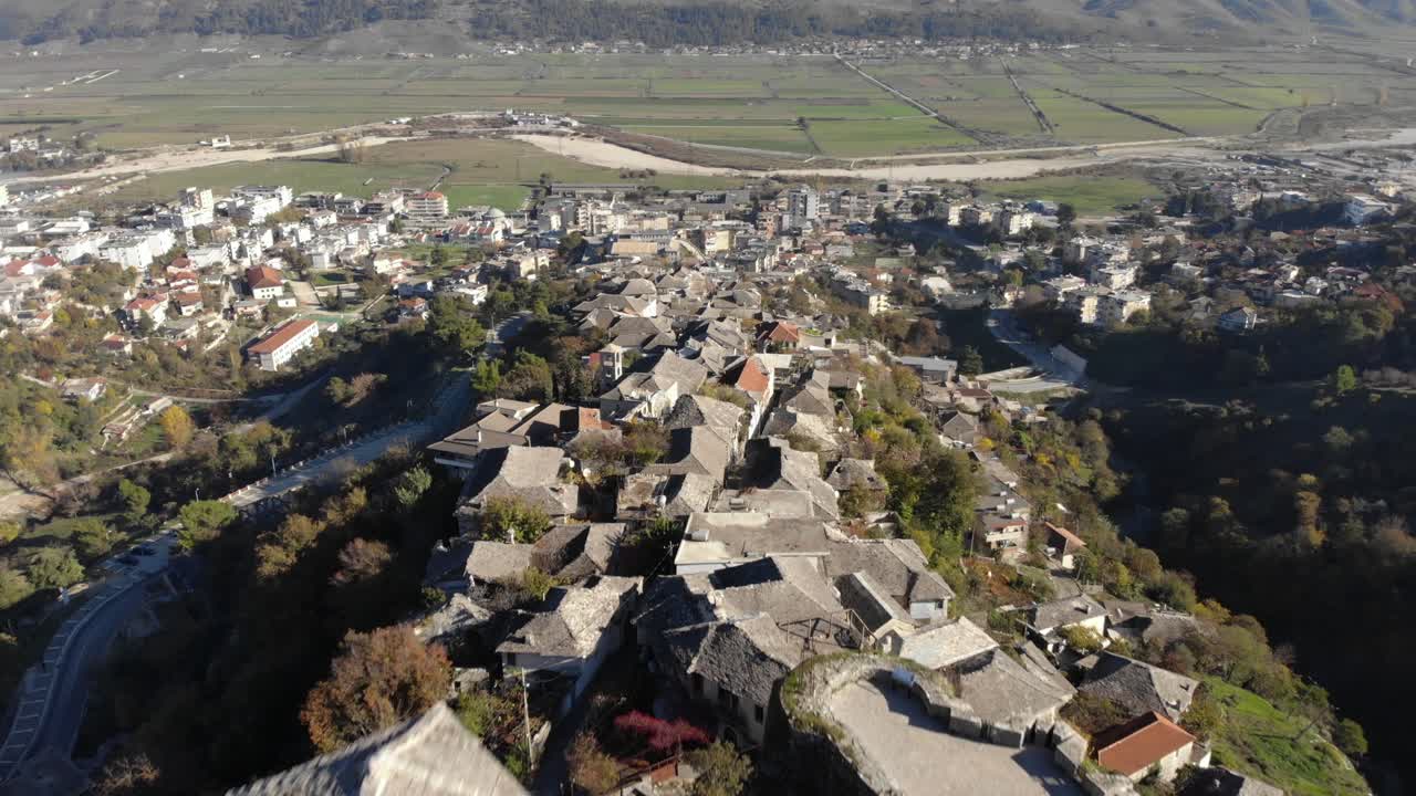 torre del reloj y paredes de piedra de la fortaleza sobre las casas tradicionales de la ciudad de gjirokastra