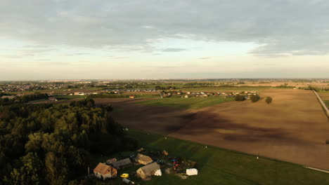 Volando-Sobre-Una-Granja-Solitaria-Que-Revela-La-Majestuosa-Ciudad-De-Ringaudai,-Vista-Aérea-De-Drones