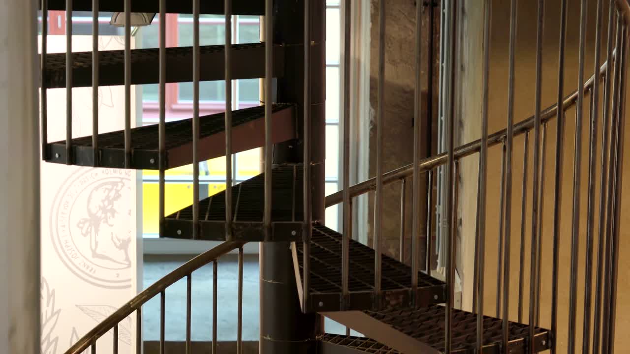 una escalera en espiral dentro del edificio con los escalones metálicos