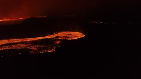 Creciente-Flujo-De-Lava-Con-Magma-Brillante-Por-La-Noche-En-Islandia,-Aéreo