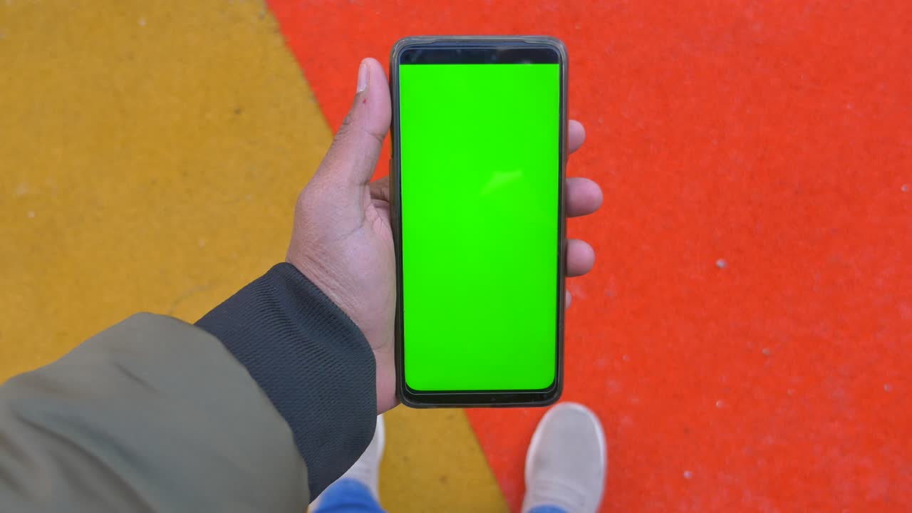 persona con un teléfono inteligente de pantalla verde