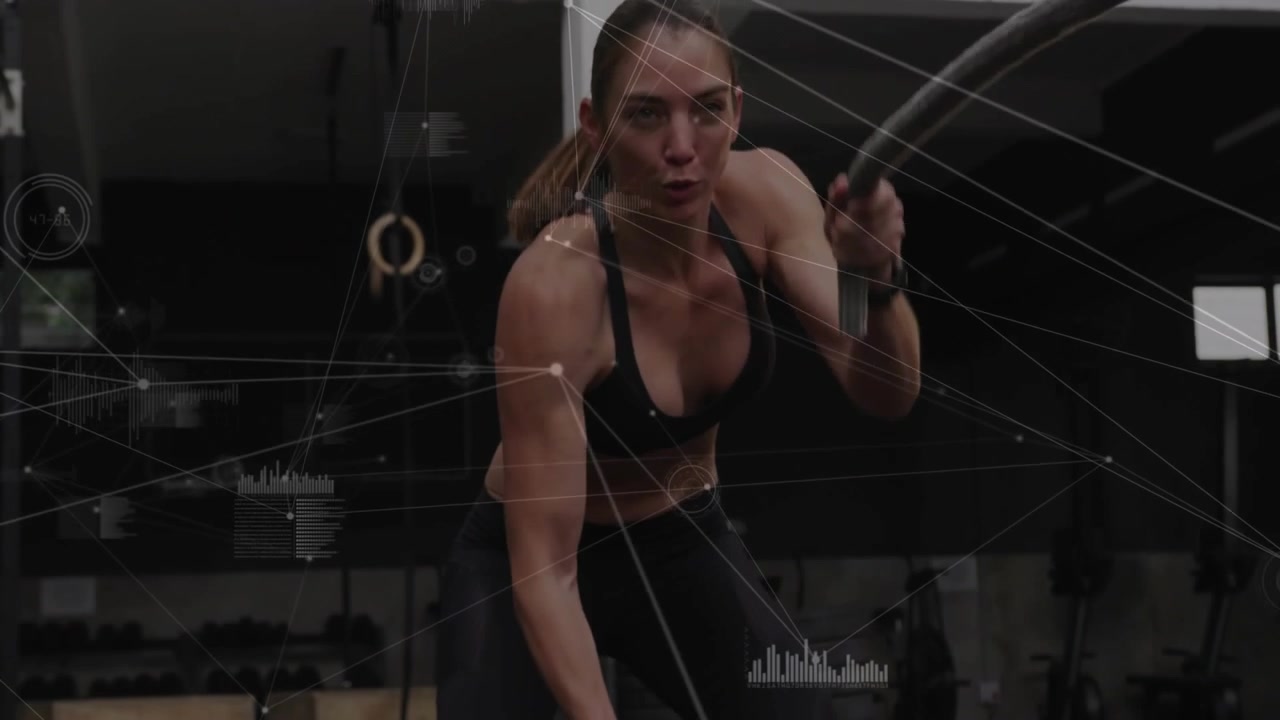 Vertical video: Woman gripping rope and doing alternating slams feeding fitness HUD metrics