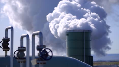 Thick-smoke-billows-out-of-the-geothermal-power-plant-chimney,-Selective-focus