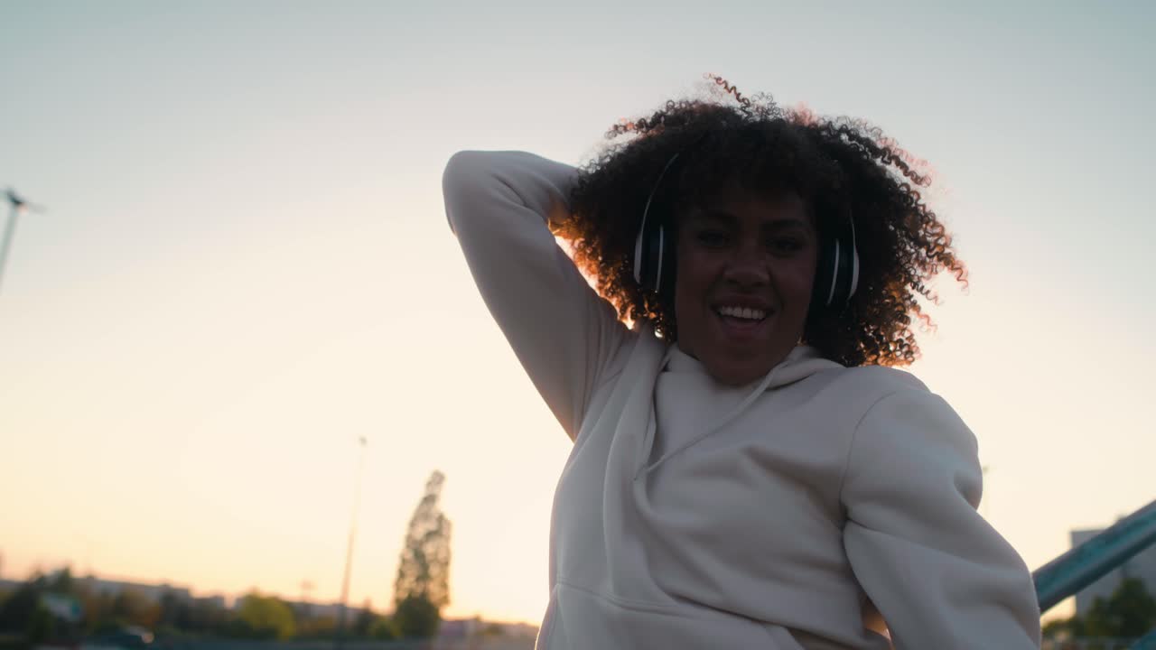 Low angle view of black woman dancing on the bridge and looking at camera