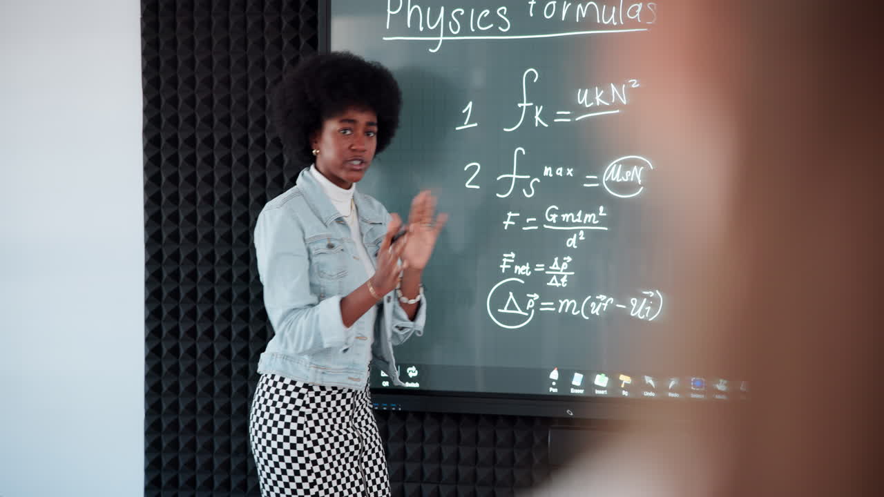 A teacher explaining physics formulas on an interactive whiteboard