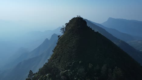 aerial drone shot of kolukkumalai range in the early morning, draped in mist and soft sunlight