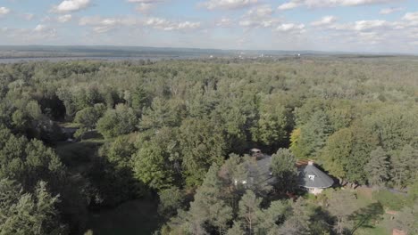 Imágenes-Aéreas-Sobre-Una-Zona-Boscosa-Con-Una-Casa-Rodeada-Por-Un-Lago-Y-Montañas-En-Una-Tarde-De-Verano-En-Ontario,-A-Las-Afueras-De-Ottawa