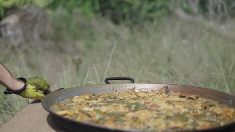 person preparing traditional paella outdoors