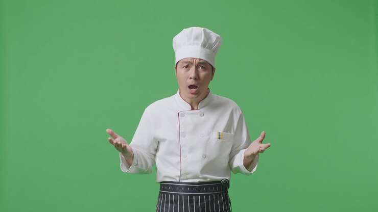 Wondering Asian Man Chef Saying Why And Standing Doubtfully In The Green Screen Background Studio