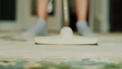 woman vacuuming a carpet in a house video with shallow depth of field