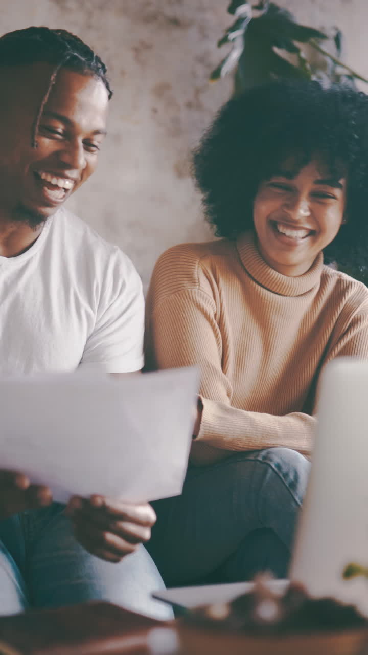Happy Young Black Couple Discussing Documents and Laughing Together
