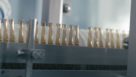 lab worker arranges bottles containing chemical liquids rotating on a conveyor machine in a modern pharmaceutical manufacturing plant