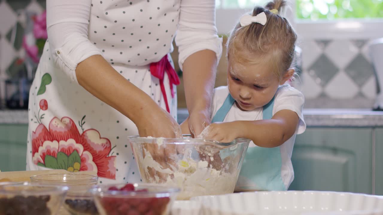 una niña feliz mezclando la masa para un pastel