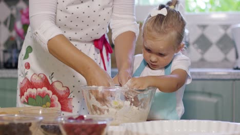 happy little girl mixing the dough for a pie