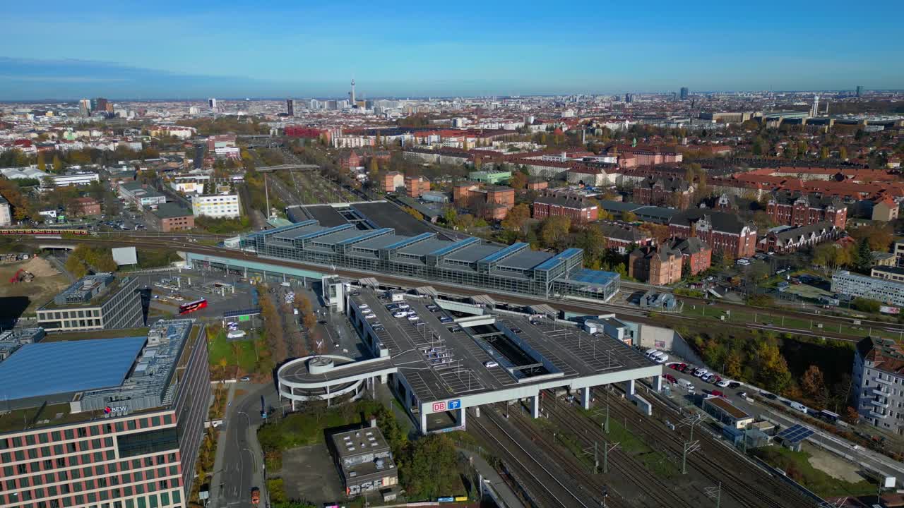 Berlin cityscape with a modern train station South Cross and extensive railway lines under a clear sky. Best aerial view flight panorama orbit drone