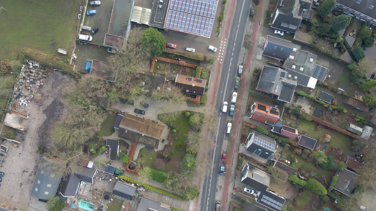 antena de arriba hacia abajo de un camión conduciendo por una carretera a través de un hermoso pueblo pequeño