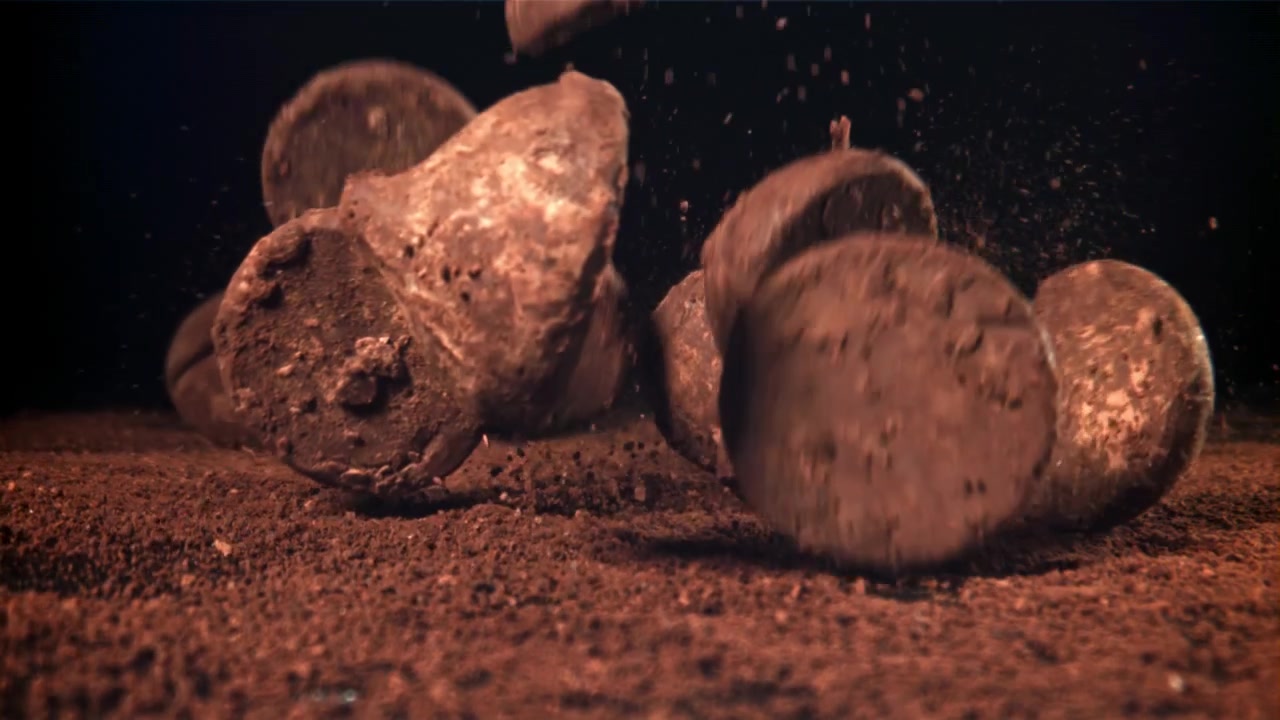 Slow Motion of Chocolate Truffles Falling onto Cocoa Powder