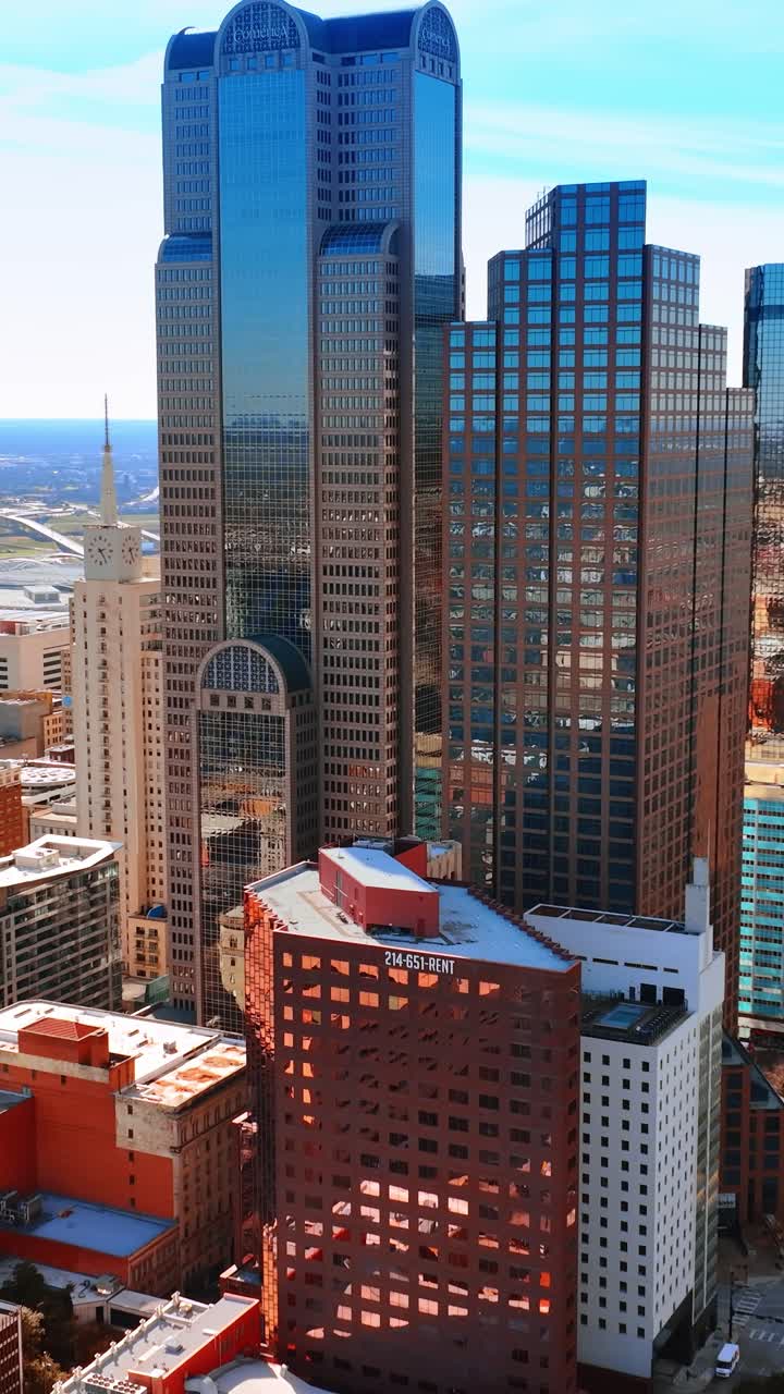 Lindas fachadas espelhadas de arranha-céus na área nobre de Dallas, Texas, EUA. Cenário ensolarado da cidade visto por drone.