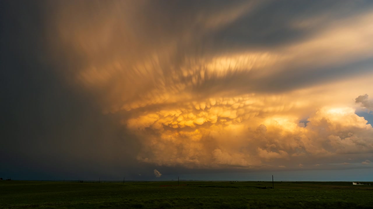 Dramatische Wolken nach dem Sturm leuchten bei Sonnenuntergang über einer stimmungsvollen Landschaft.