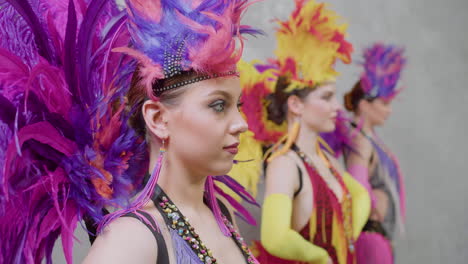 Vista-De-Cerca-De-Tres-Chicas-Bailando-Con-Vestidos-Coloridos-Y-Moviendo-La-Cabeza-De-Lado-A-Lado