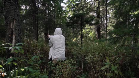 man in white clothing hiking through the woods