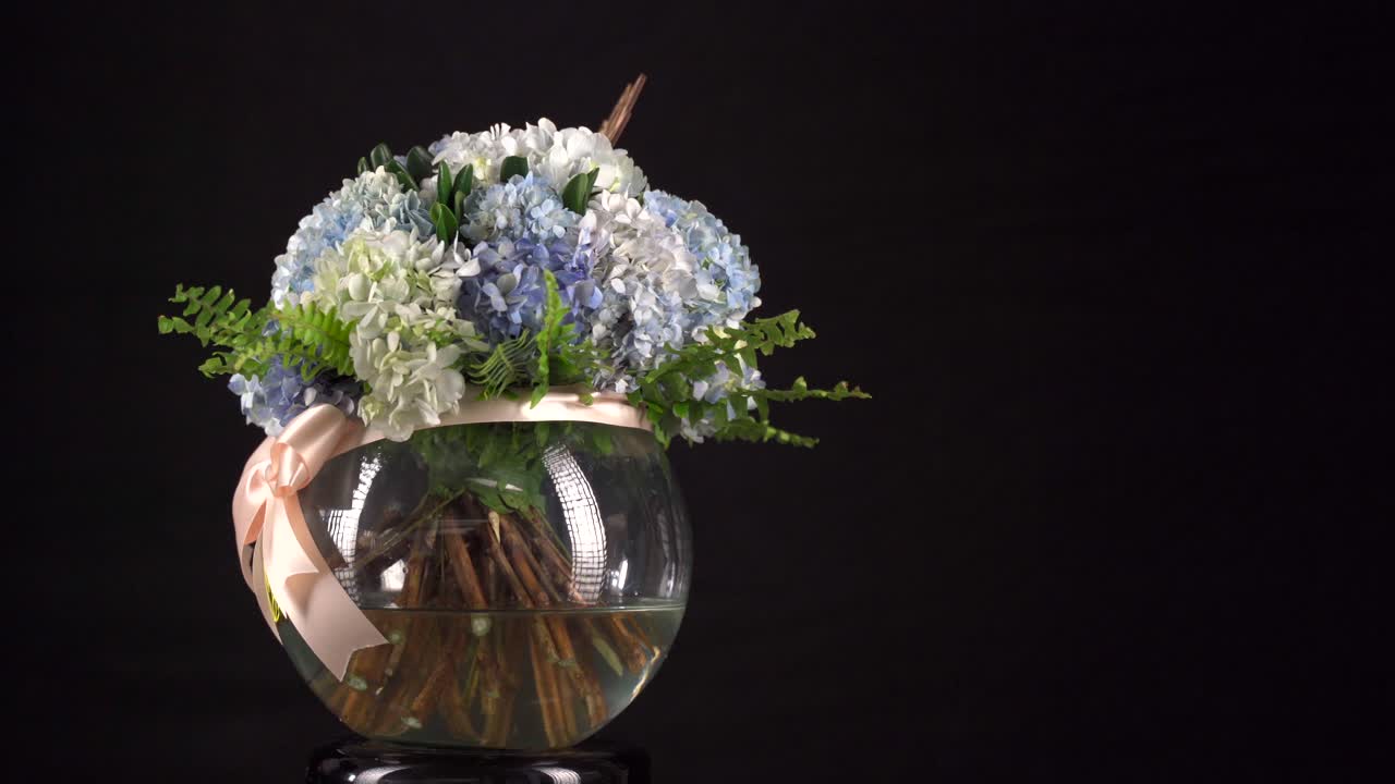 arreglo de tanque de agua de clavel con cinta girando en tiro deslizante de fondo negro