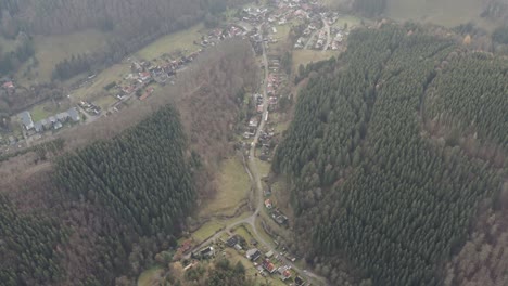 Impressions-of-the-Harz-national-park-on-a-dark-moody-day,-captured-by-a-drone-flying-very-high-and-in-between-trees-with-beautiful-orange-and-red-leaves,-North-Germany,-Europe