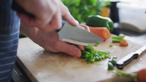 Primer-Plano-De-La-Mano-Del-Hombre-Cortando-Pimiento-Verde-En-La-Tabla-De-Cortar