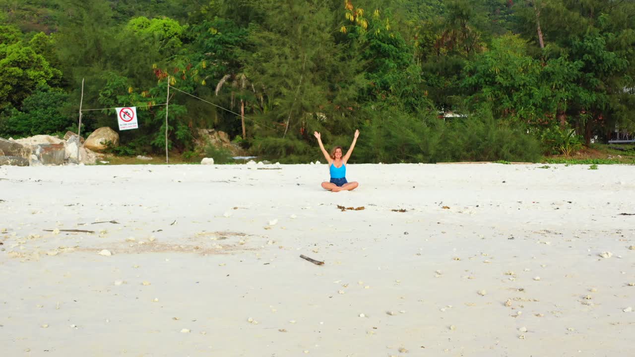 Caucasian pretty woman stretching and meditating on the wild sand beach, Thailand