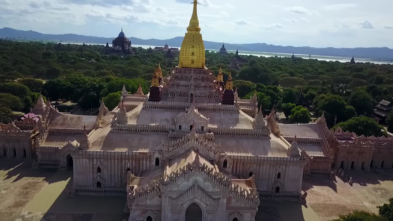 A captivating low-angle shot of the White Temple at Ananda Temple in Bagan, Myanmar, highlighting the gleaming golden Sertok and the temple's rich architectural and cultural significance.