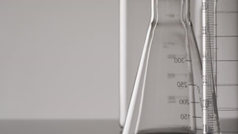 Video-of-close-up-of-glass-laboratory-beakers-and-dishes-with-copy-space-on-white-background