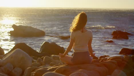 mujer realizando yoga en la playa 4k